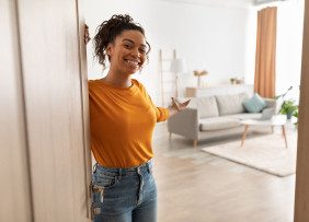 Woman At The Door To Her Home Gesturing To The Living Room Gettyimages 1372309567 1300w 867h.jpg